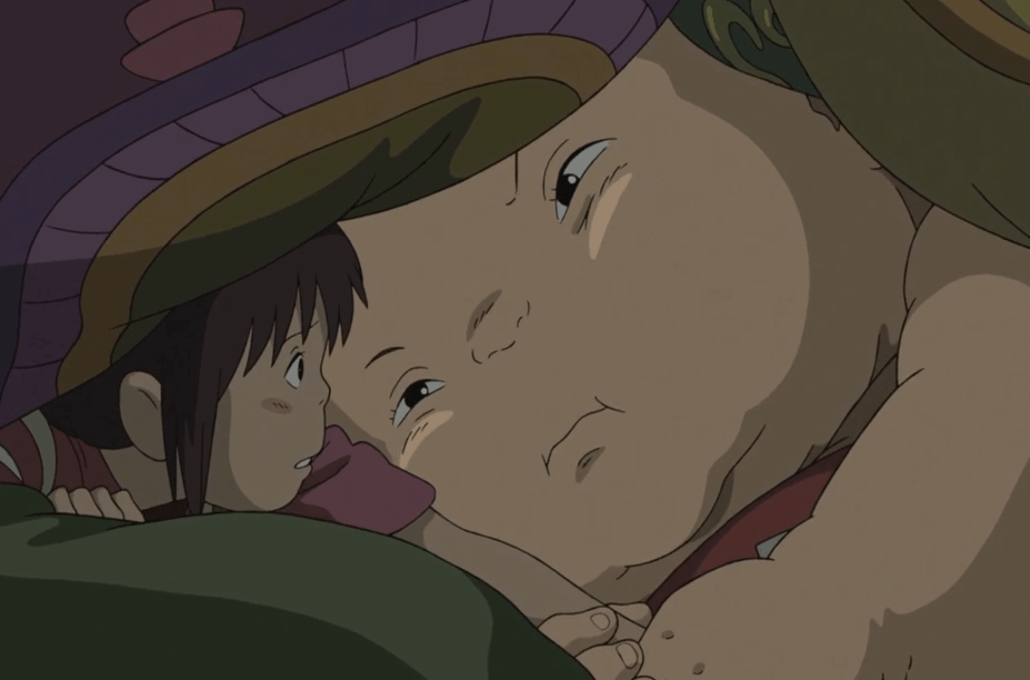 A giant baby (named Boh in the movie) is grabbing Chihiro's arm and threatening to break it if she doesn't play with him.
