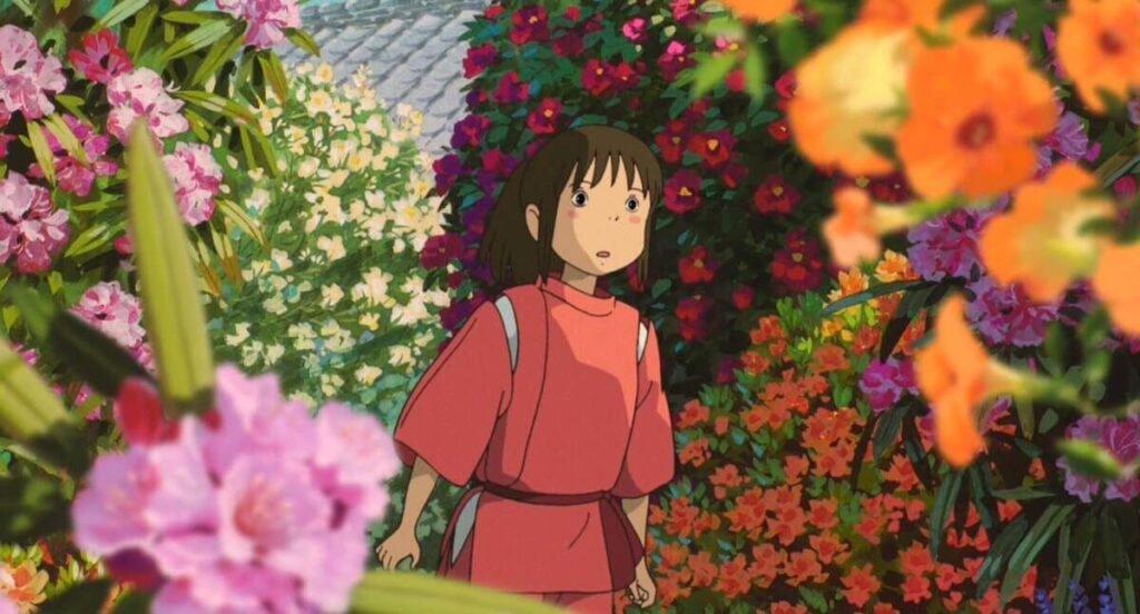 Chihiro, a brunette in a pink Japanese outfit, wandering amongst  multi-colored flowers.