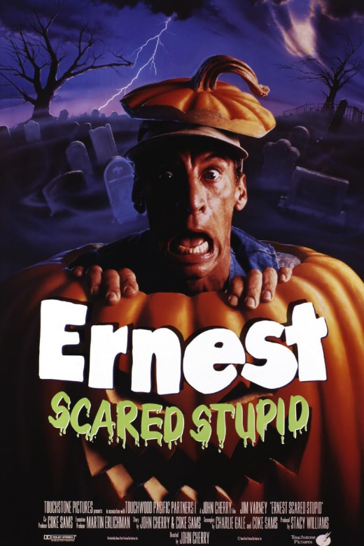 Movie poster for Enrest Scared Stupid with a frightened man popping out of a giant jack-o-lantern in a spooky purple-tinted graveyard.